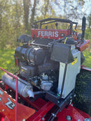 Close-up of a red and black Ferris lawn mower 28 Hp Vanguard engine, with a grey Oil Guard system tank on the side, photographed outdoors with trees and grass in the background.