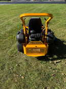photo of the rear of a yellow and black zero turn you can see the engine
